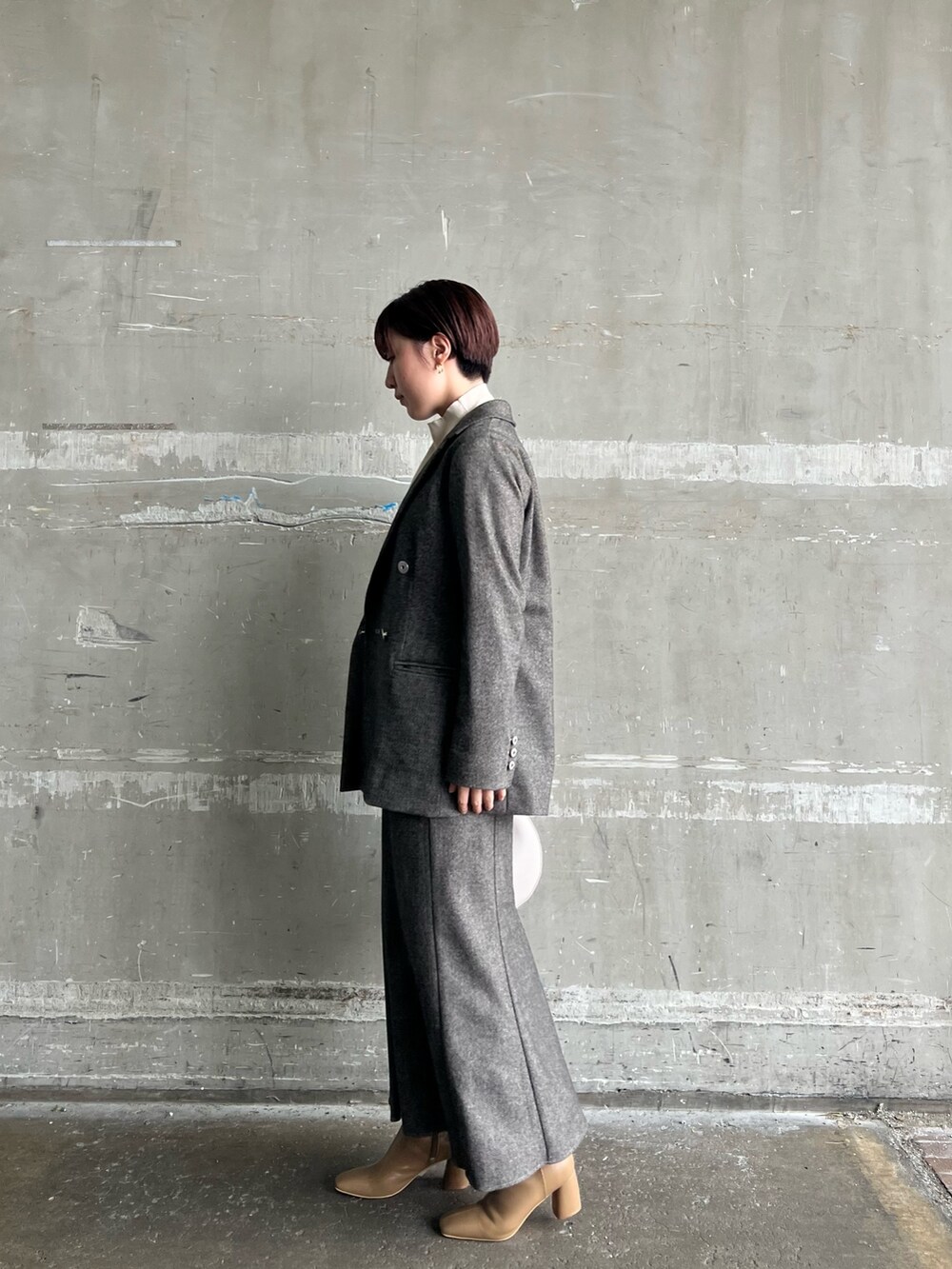 ブラウン系のスカート、ブラウン系のテーラードジャケット、ホワイト系のハンドバッグを着用したレディースの秋コーディネートの2枚目の写真