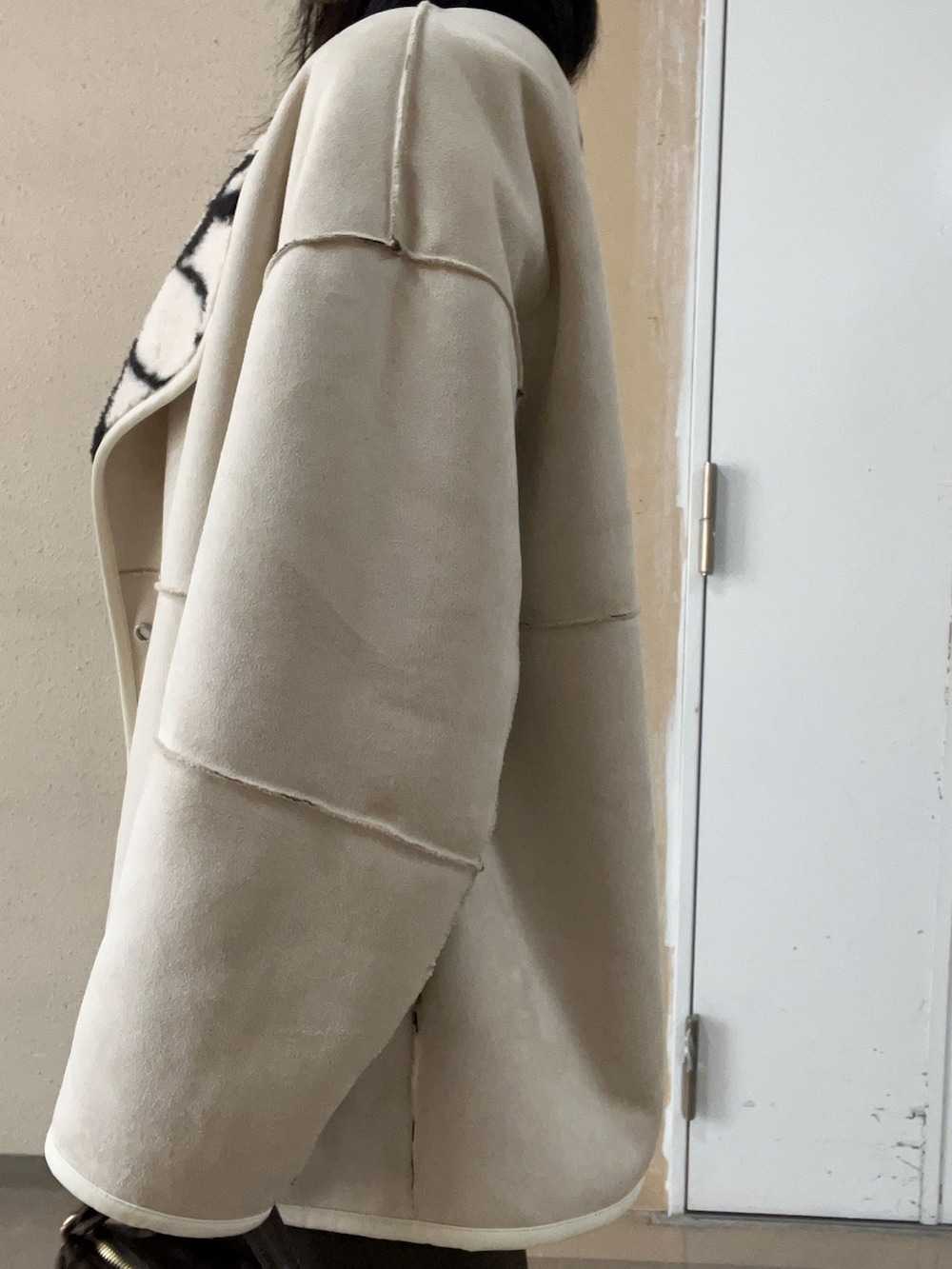 ホワイト系のブルゾン、ブラック系のブーツ、ブラック系のニット/セーターを着用したレディースの秋コーディネートの5枚目の写真