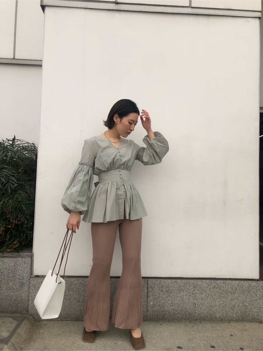 ベージュ系のその他パンツ、ベージュ系のサンダル、ホワイト系のハンドバッグを着用したレディースの春コーディネートの3枚目の写真