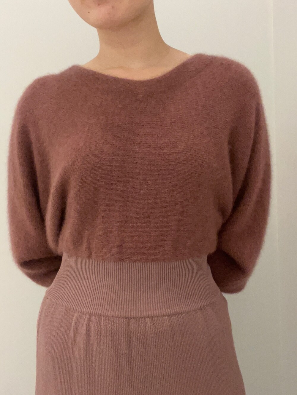 ピンク系のカーディガン/ボレロ、ピンク系のワンピース、ベージュ系のブーツを着用したレディースの秋コーディネートの6枚目の写真