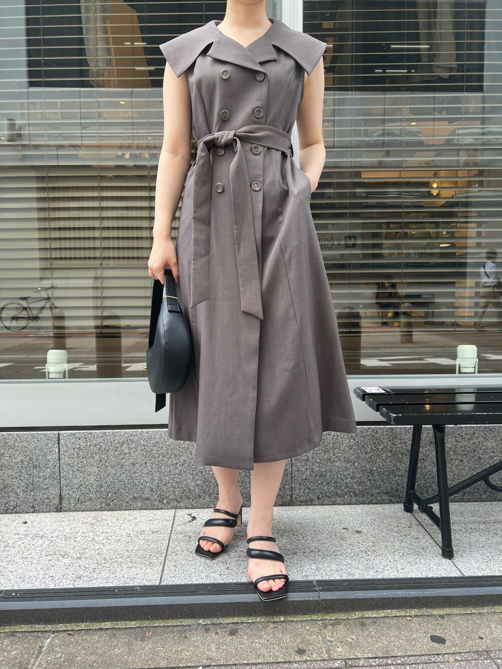 グレー系のワンピース、ブラック系のサンダル、ブラック系のハンドバッグを着用したレディースの夏コーディネートの8枚目の写真