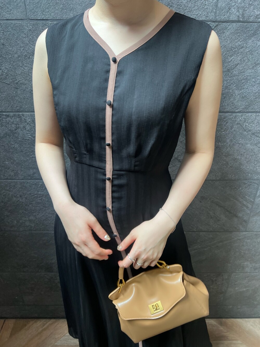 ブラック系のワンピース、ホワイト系のサンダル、レッド系のハンドバッグを着用したレディースの夏コーディネートの4枚目の写真