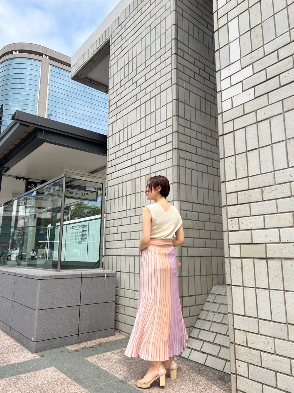 オレンジ系のスカート、その他のパンプス、ホワイト系のショルダーバッグを着用したレディースの春コーディネートの9枚目の写真