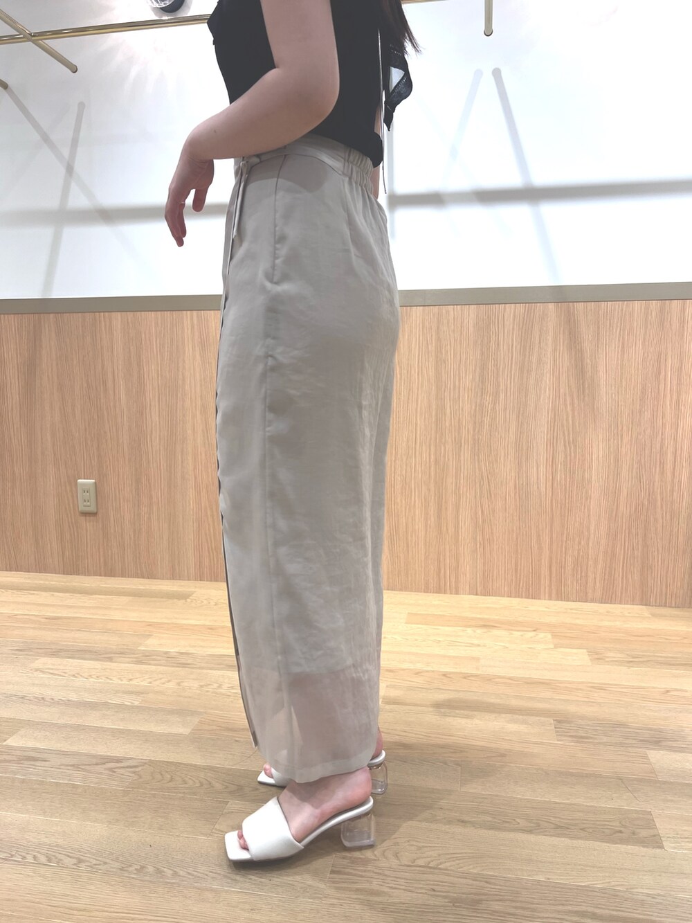 ブラック系のニット/セーター、ホワイト系のスカート、ホワイト系のサンダルを着用したレディースの春コーディネートの8枚目の写真