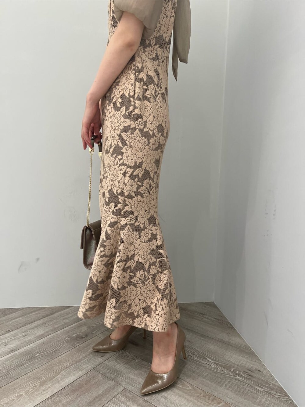 ゴールド系のクラッチバッグ、ゴールド系のパンプス、ベージュ系のドレスを着用したレディースの夏コーディネートの9枚目の写真