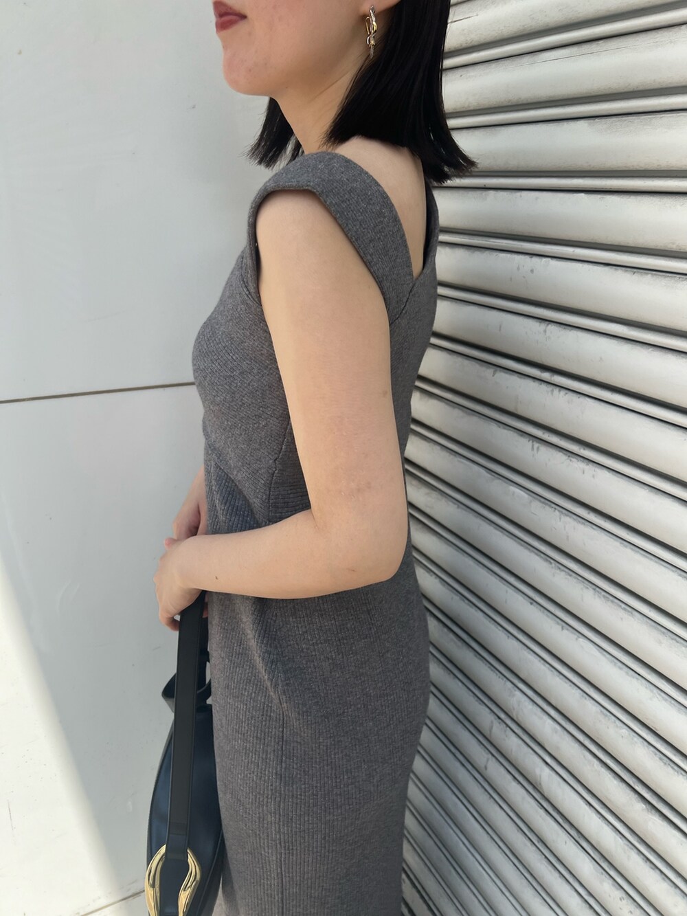 グレー系のワンピース、ブラック系のサンダル、ブラック系のショルダーバッグを着用したレディースの夏コーディネートの7枚目の写真