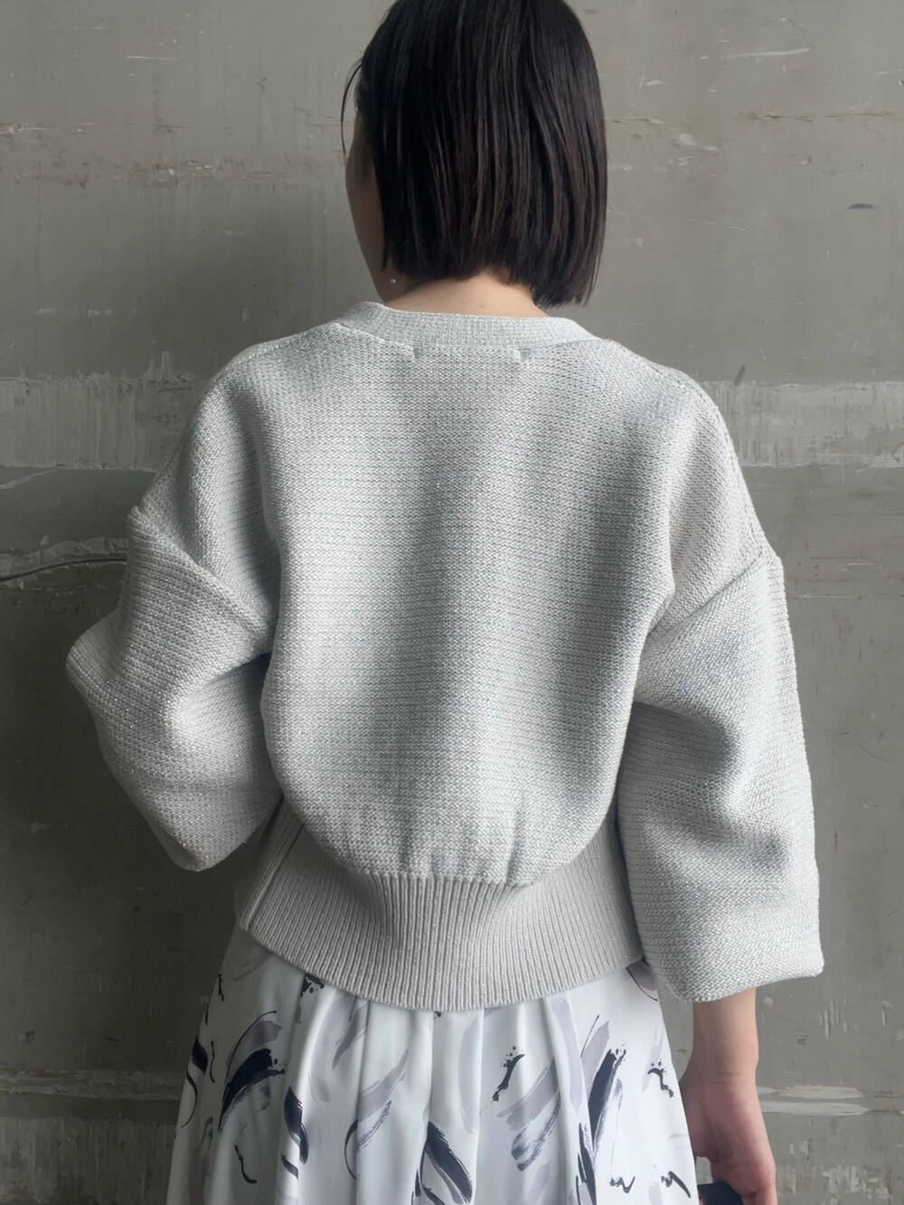 ブラック系のハンドバッグ、グレー系のカーディガン/ボレロ、ホワイト系のワンピースを着用したレディースの春コーディネートの8枚目の写真