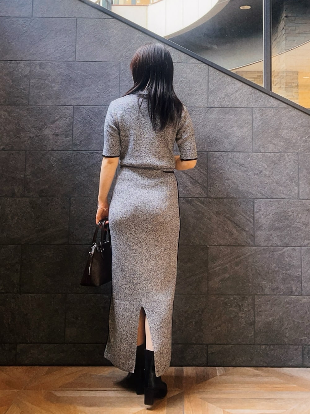 ブラック系のワンピース、ブラック系のブーツ、ブラウン系のボストンバッグを着用したレディースの夏コーディネートの3枚目の写真