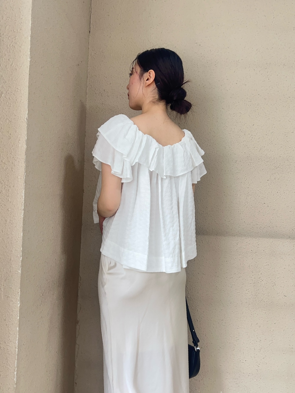 ホワイト系のシャツ/ブラウス、ホワイト系のスカート、ブラック系のパンプスを着用したレディースの春コーディネートの2枚目の写真