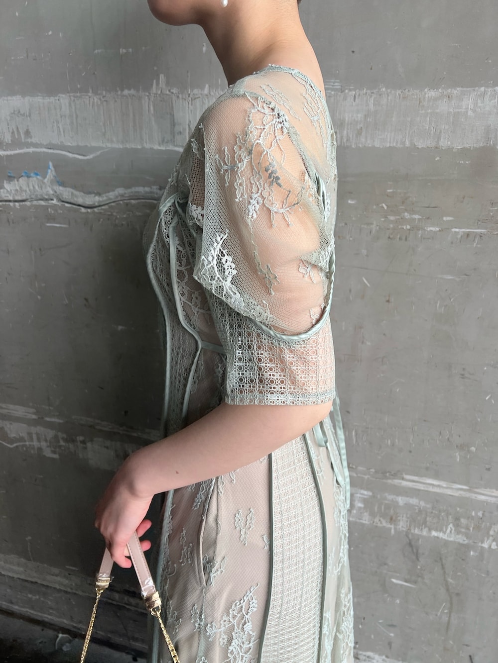 グリーン系のドレス、ベージュ系のパンプス、ベージュ系のクラッチバッグを着用したレディースの春コーディネートの5枚目の写真