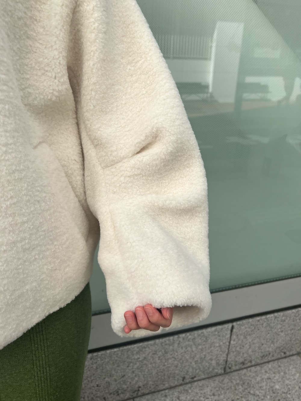 ブラウン系のショルダーバッグ、ベージュ系のブーツ、グリーン系のワンピースを着用したレディースの秋コーディネートの6枚目の写真