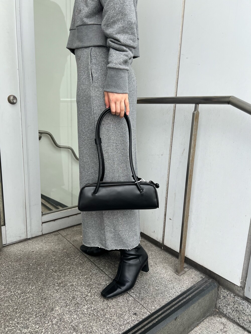 ブラック系のブーツ、グレー系のスカート、グレー系のスウェットを着用したレディースの秋コーディネートの8枚目の写真