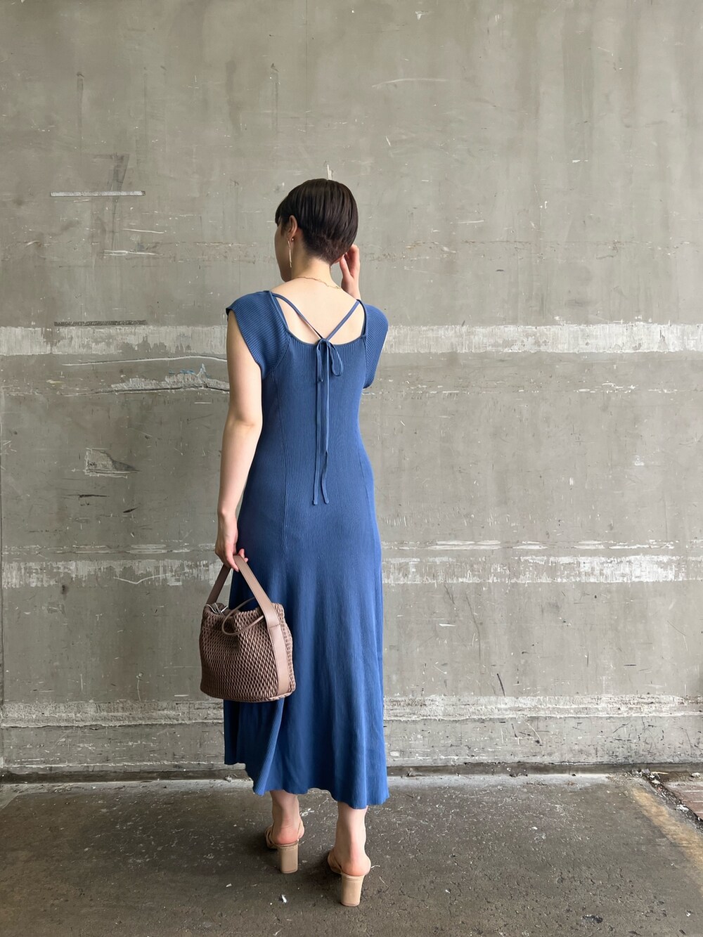 ホワイト系のハンドバッグ、ブルー系のワンピース、ベージュ系のサンダルを着用したレディースの夏コーディネートの2枚目の写真