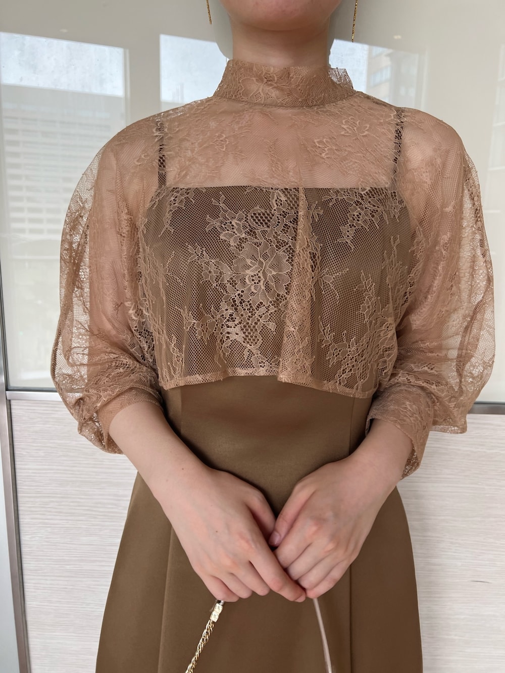 ベージュ系のクラッチバッグ、ブラウン系のドレス、ベージュ系のパンプスを着用したレディースの夏コーディネートの5枚目の写真