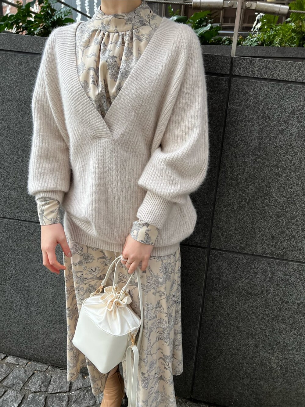 ホワイト系のニット/セーター、ベージュ系のその他シューズ、ホワイト系のワンピースを着用したレディースの冬コーディネートの2枚目の写真