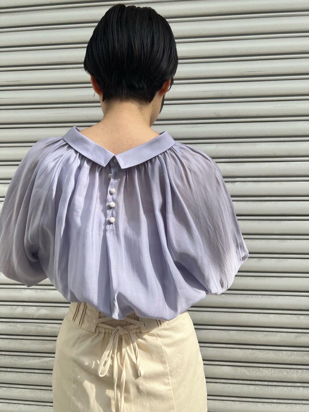 レッド系のブーツ、ホワイト系のスカート、ホワイト系のカーディガン/ボレロを着用したレディースの冬コーディネートの7枚目の写真