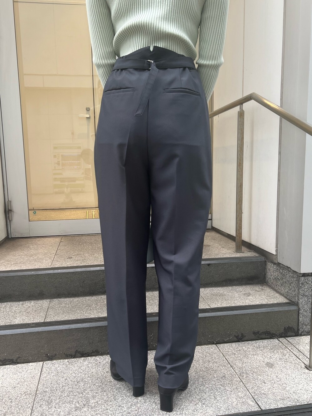 ブルー系のショルダーバッグ、グレー系のスラックス、グリーン系のニット/セーターを着用したレディースの冬コーディネートの9枚目の写真