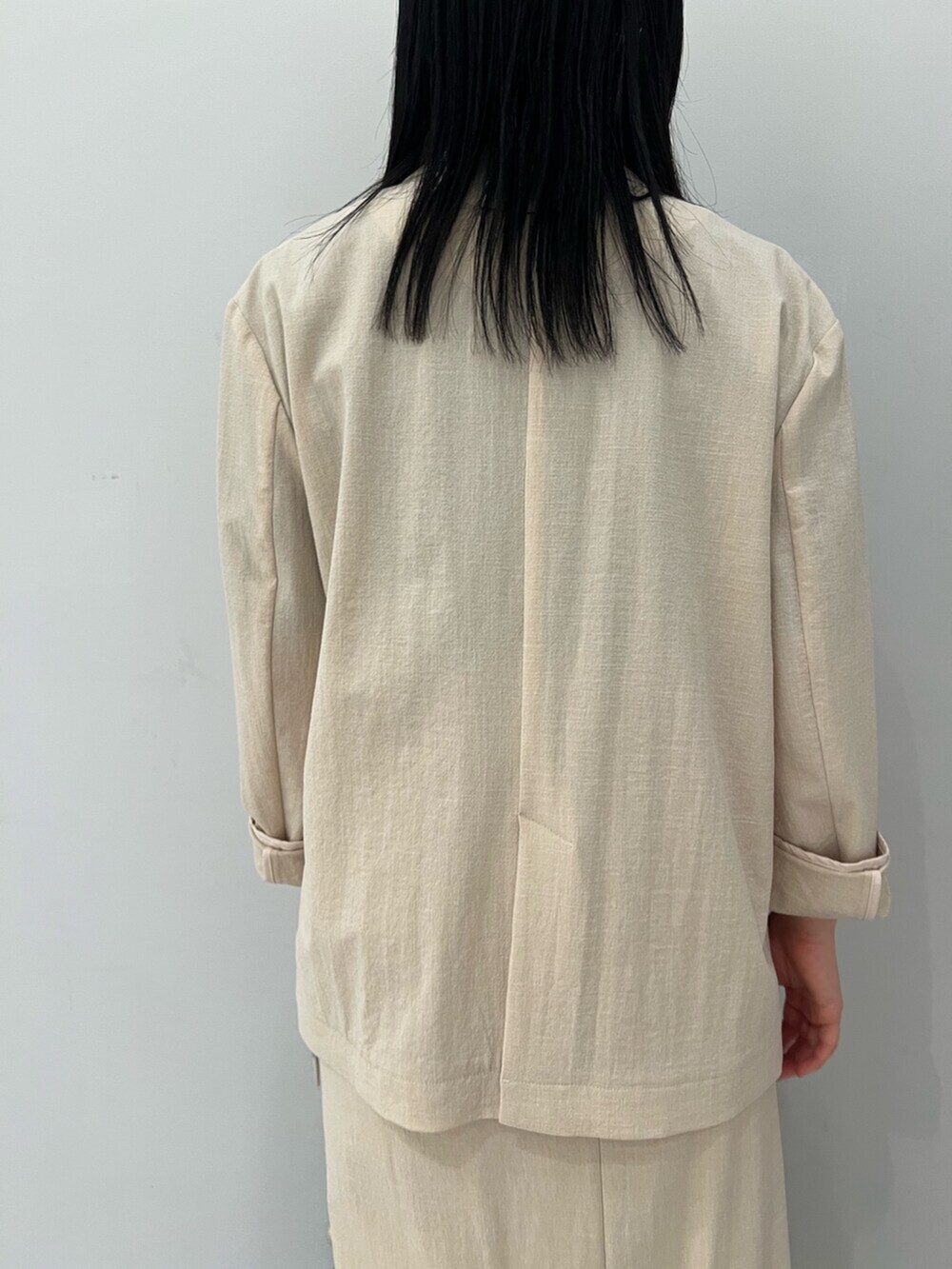 ブルー系のニット/セーター、ホワイト系のサンダル、ベージュ系のテーラードジャケットを着用したレディースの春コーディネートの6枚目の写真