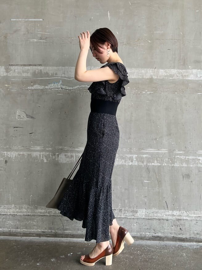 ベージュ系のハンドバッグ、ブラウン系のパンプス、ブラック系のワンピースを着用したレディースの夏コーディネートの2枚目の写真