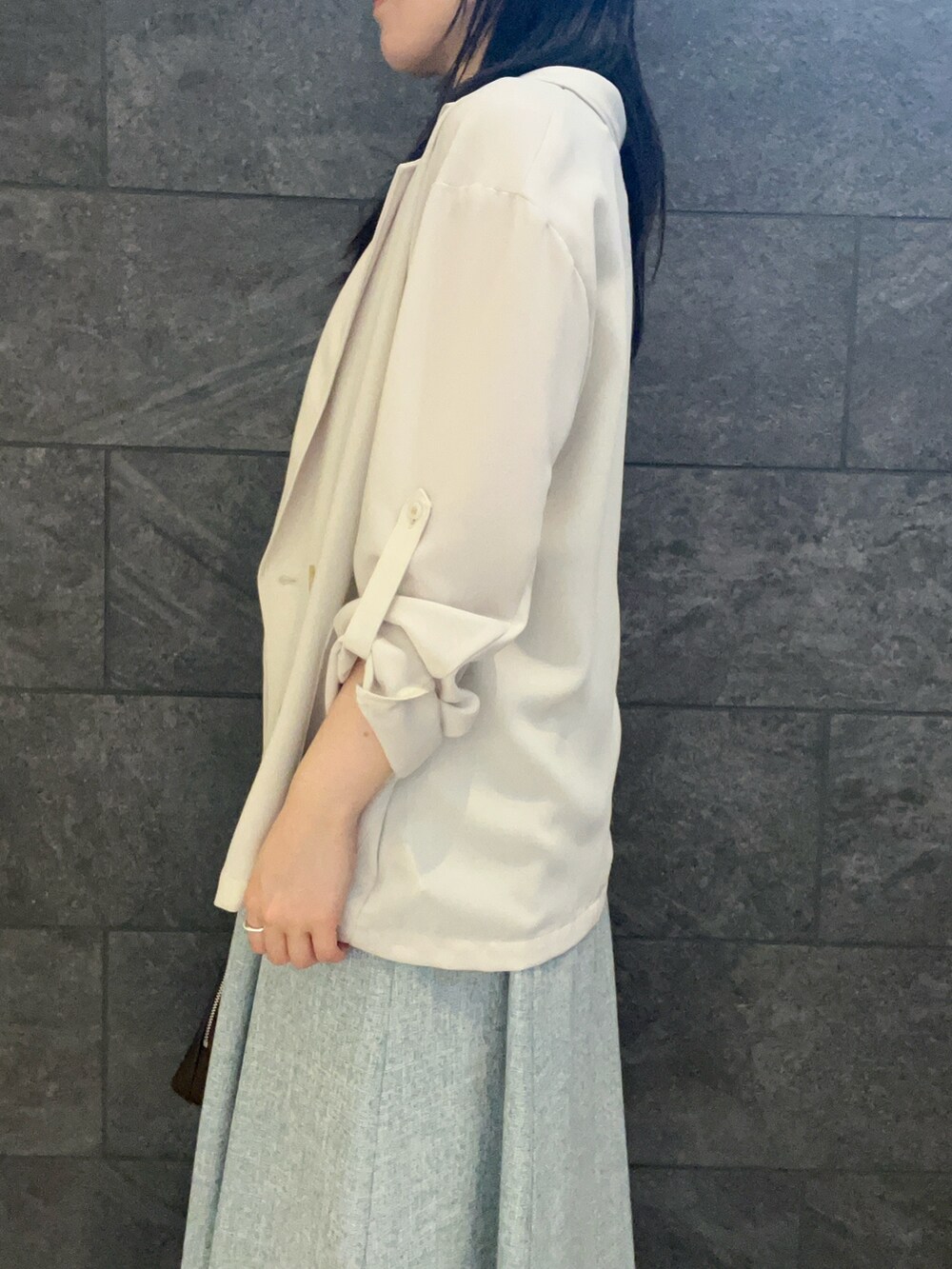 ベージュ系のテーラードジャケット、ブルー系のワンピース、ブラウン系のパンプスを着用したレディースの夏コーディネートの5枚目の写真