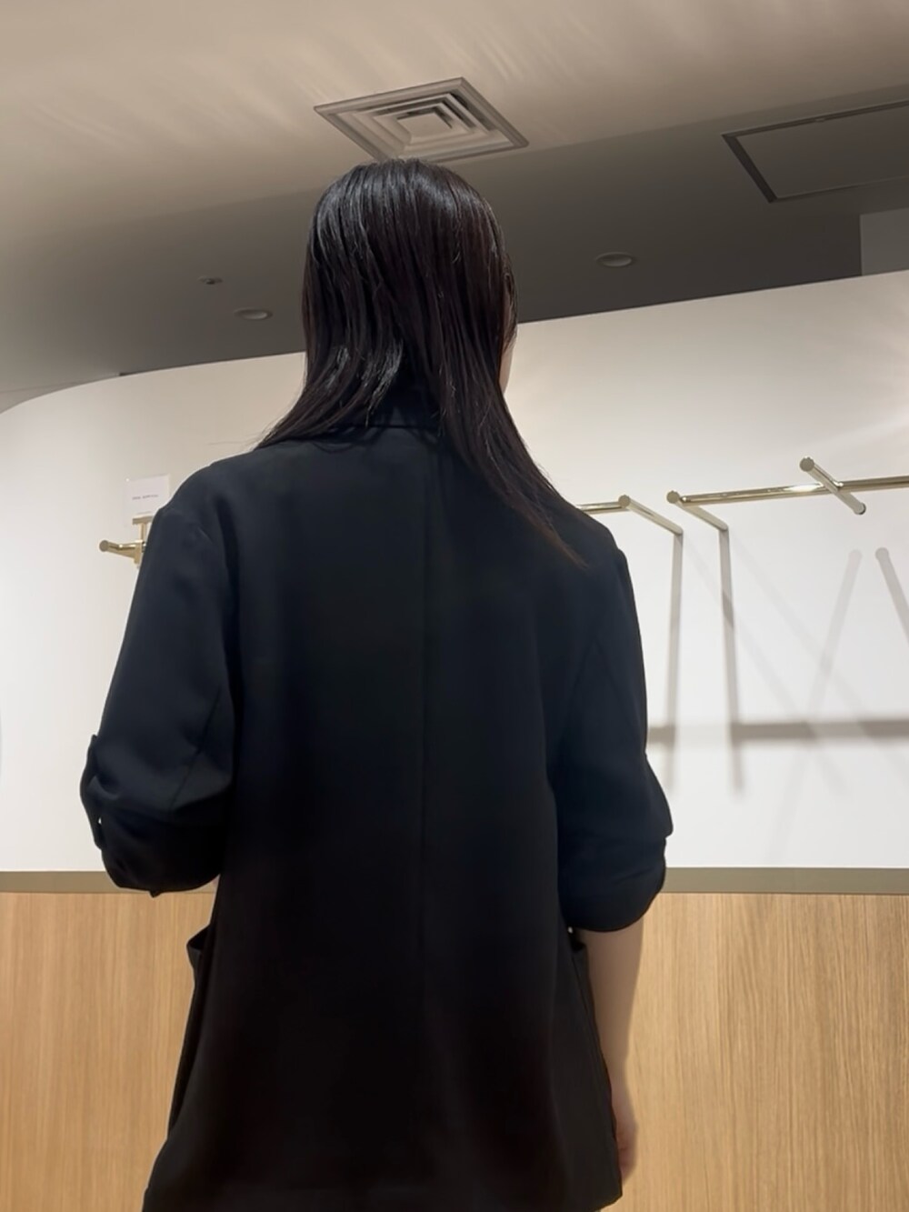 グリーン系のワンピース、ブラック系のテーラードジャケットを着用したレディースの夏コーディネートの5枚目の写真