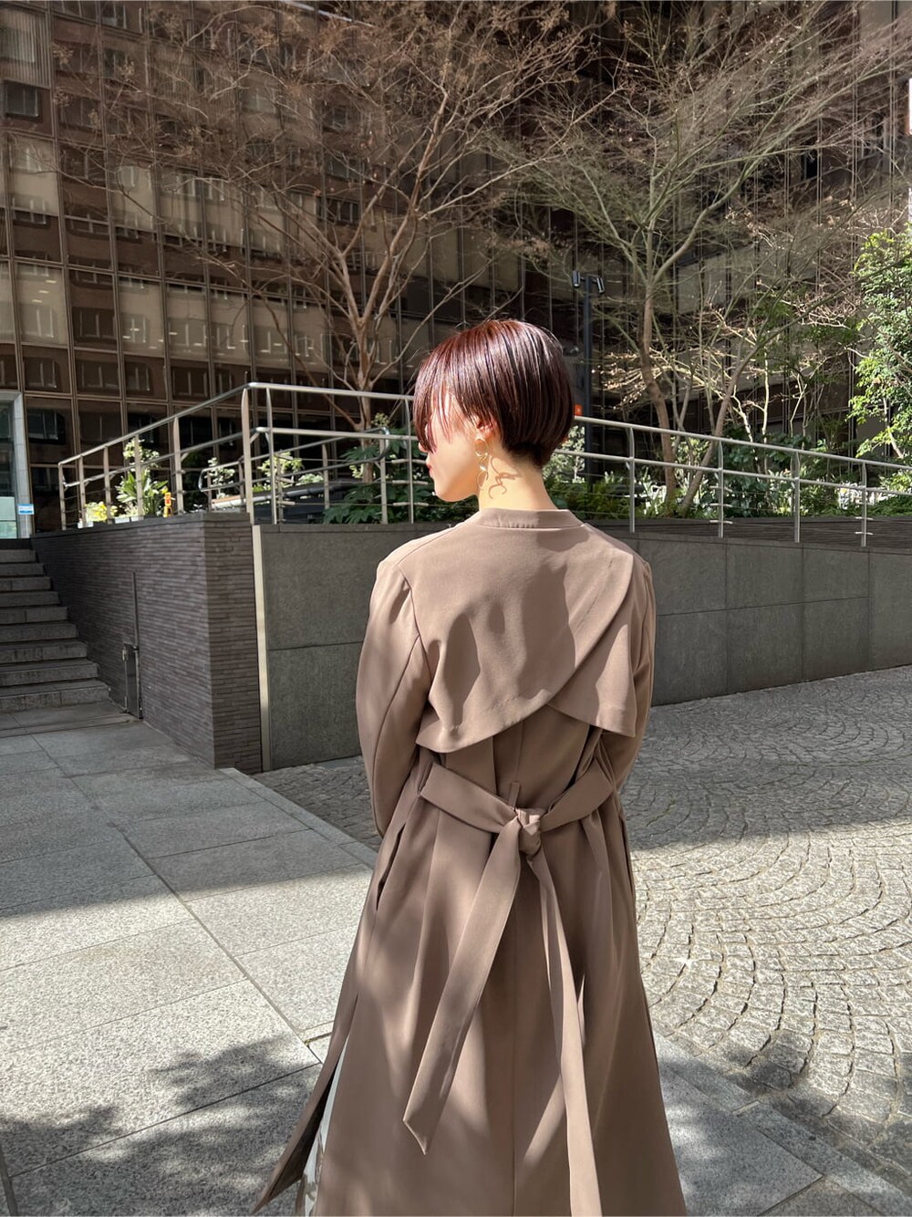 イエロー系のその他アウター、ベージュ系のスカート、ホワイト系のニット/セーターを着用したレディースの冬コーディネートの7枚目の写真