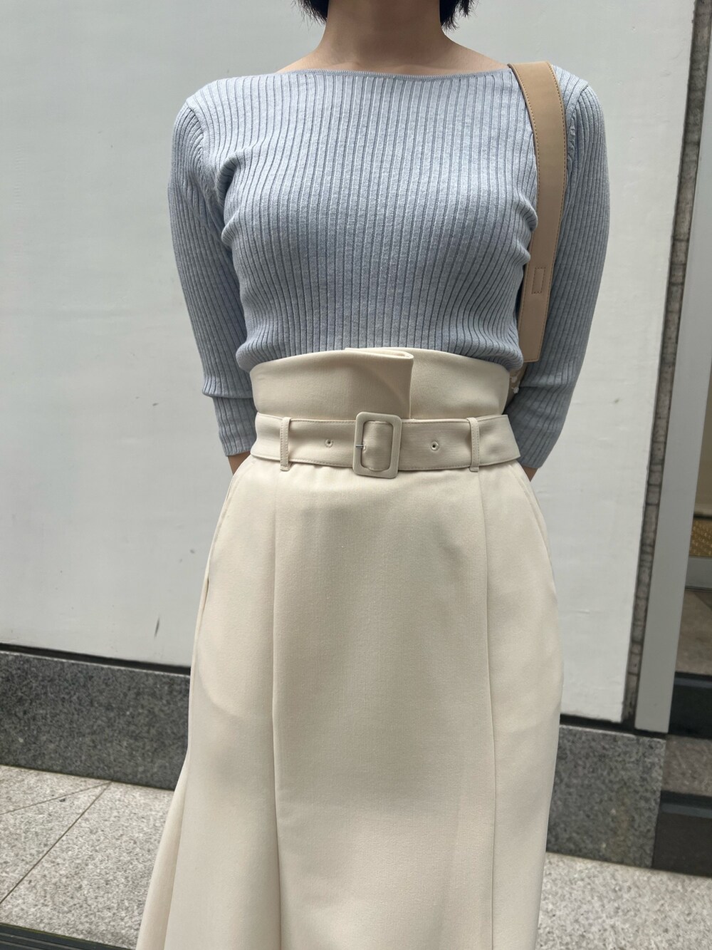 ホワイト系のパンプス、ベージュ系のハンドバッグ、ブルー系のニット/セーターを着用したレディースの春コーディネートの4枚目の写真