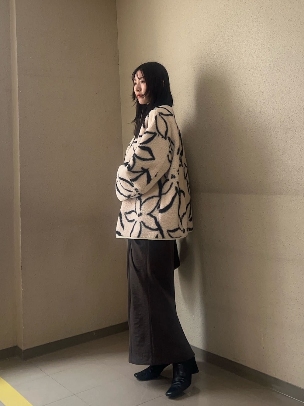 ブラック系のブーツ、ホワイト系のブルゾン、ブラック系のニット/セーターを着用したレディースの秋コーディネートの2枚目の写真