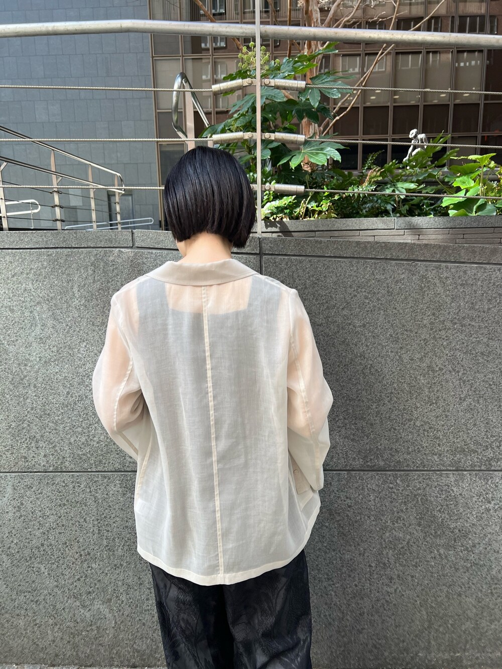 イエロー系のサンダル、ホワイト系のテーラードジャケット、ブラック系のつなぎ/オールインワンを着用したレディースの春コーディネートの4枚目の写真