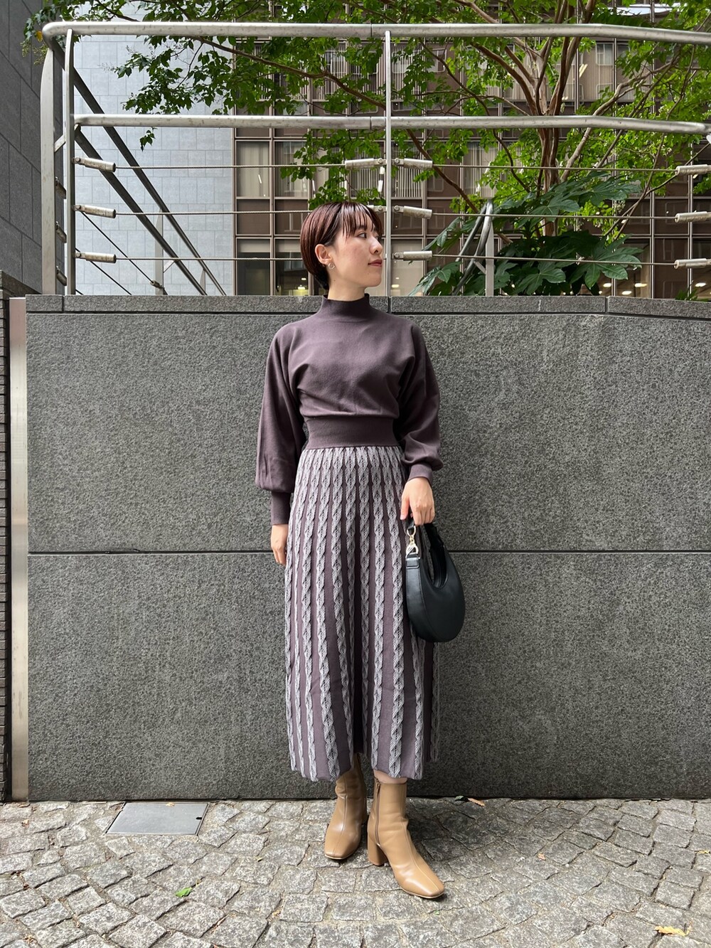 ベージュ系のブーツ、ブラック系のハンドバッグ、ブルー系のムートンコートを着用したレディースの秋コーディネートの7枚目の写真