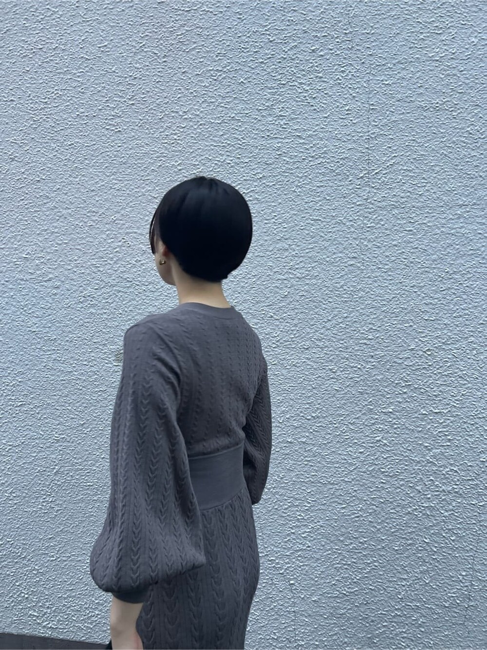 ブラウン系のワンピース、ベージュ系のブーツ、ブラック系のハンドバッグを着用したレディースの秋コーディネートの9枚目の写真