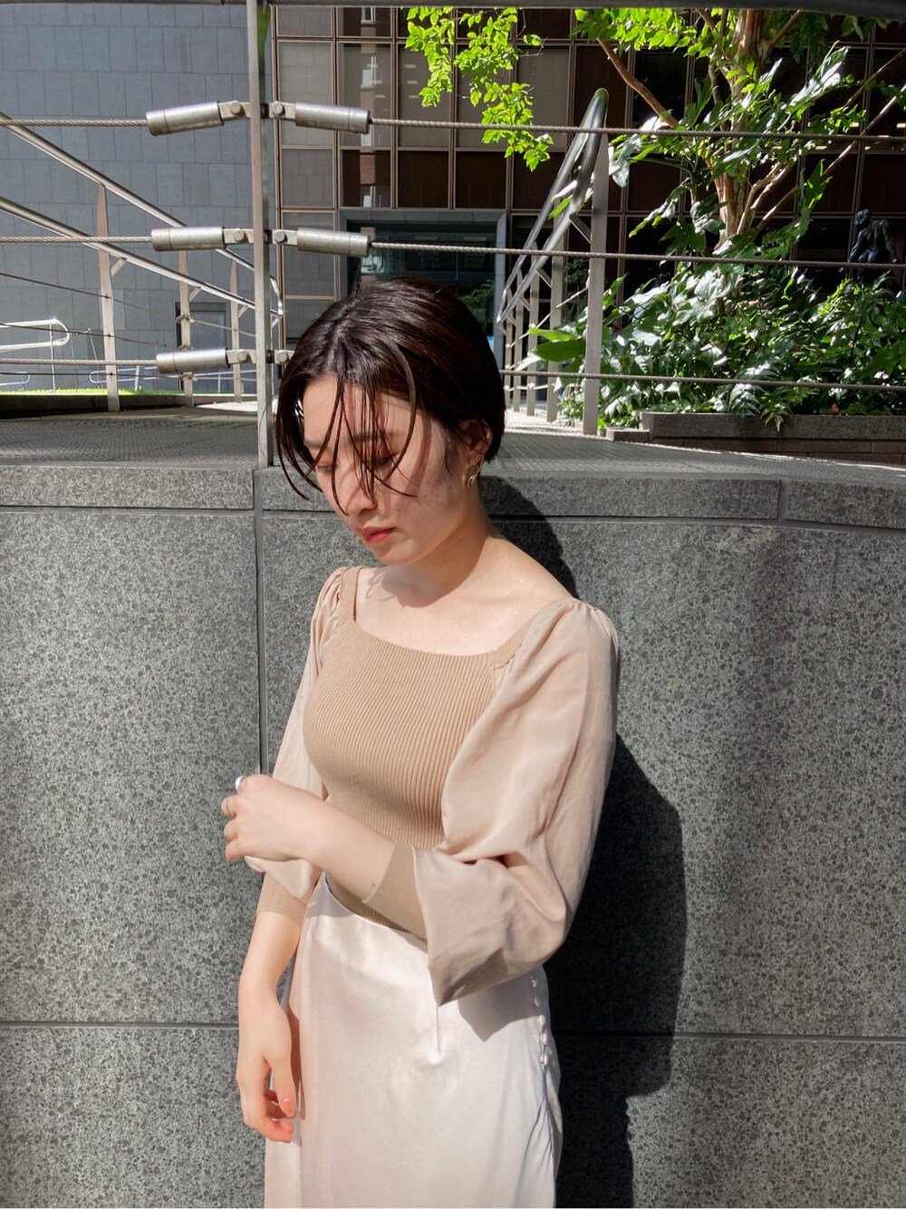 ホワイト系のスカート、ベージュ系のブーツ、ブラウン系のショルダーバッグを着用したレディースの秋コーディネートの4枚目の写真