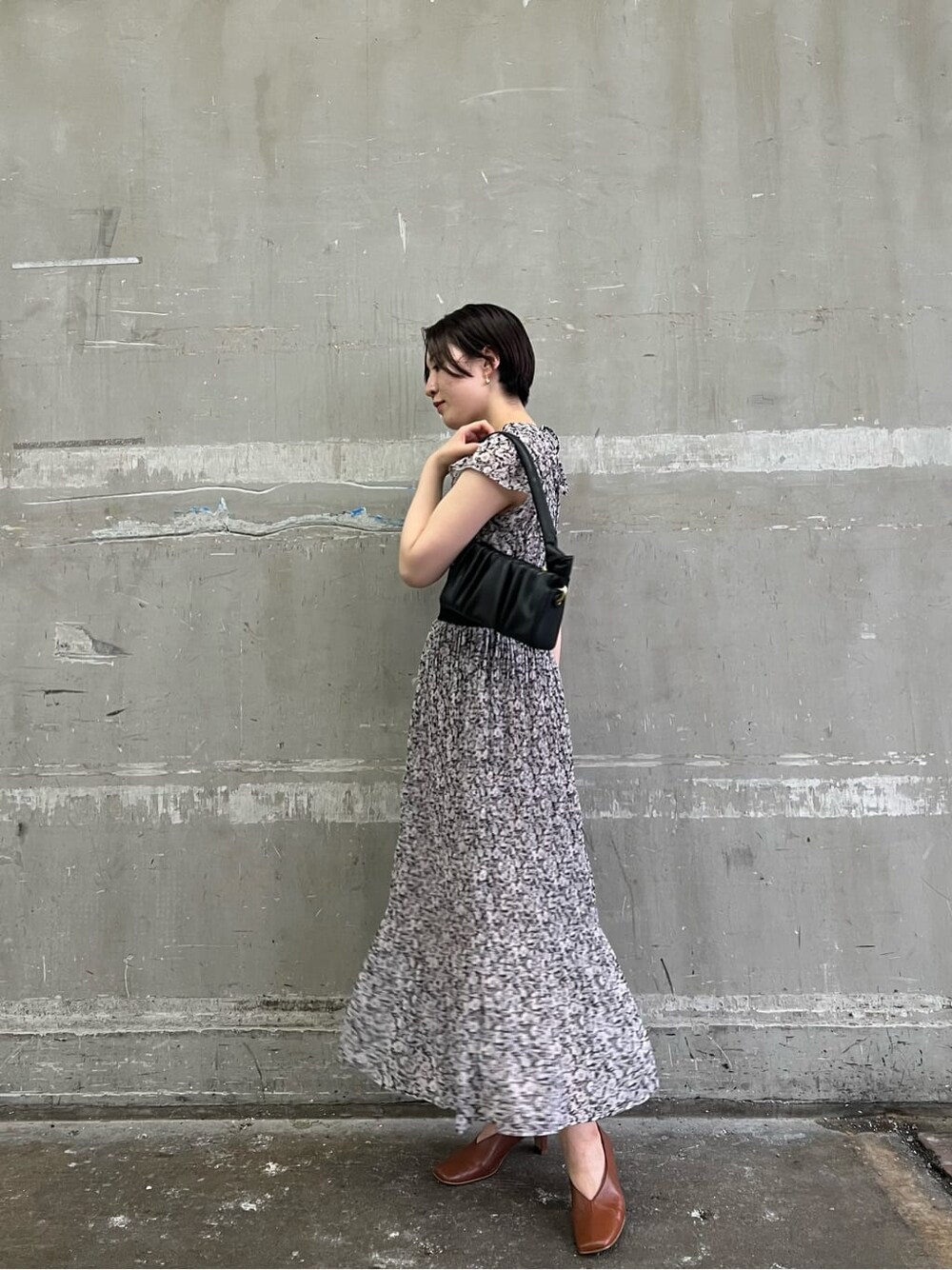 ブラウン系のパンプス、ブラック系のワンピース、ブラック系のハンドバッグを着用したレディースの夏コーディネートの2枚目の写真