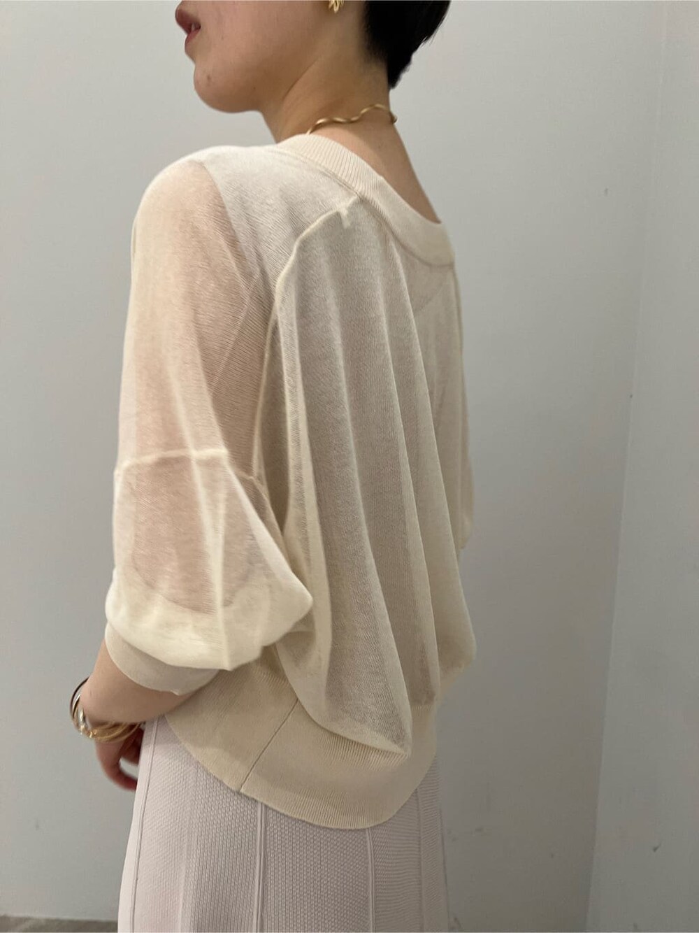 グリーン系のサンダル、ベージュ系のワンピース、ホワイト系のカーディガン/ボレロを着用したレディースの夏コーディネートの4枚目の写真