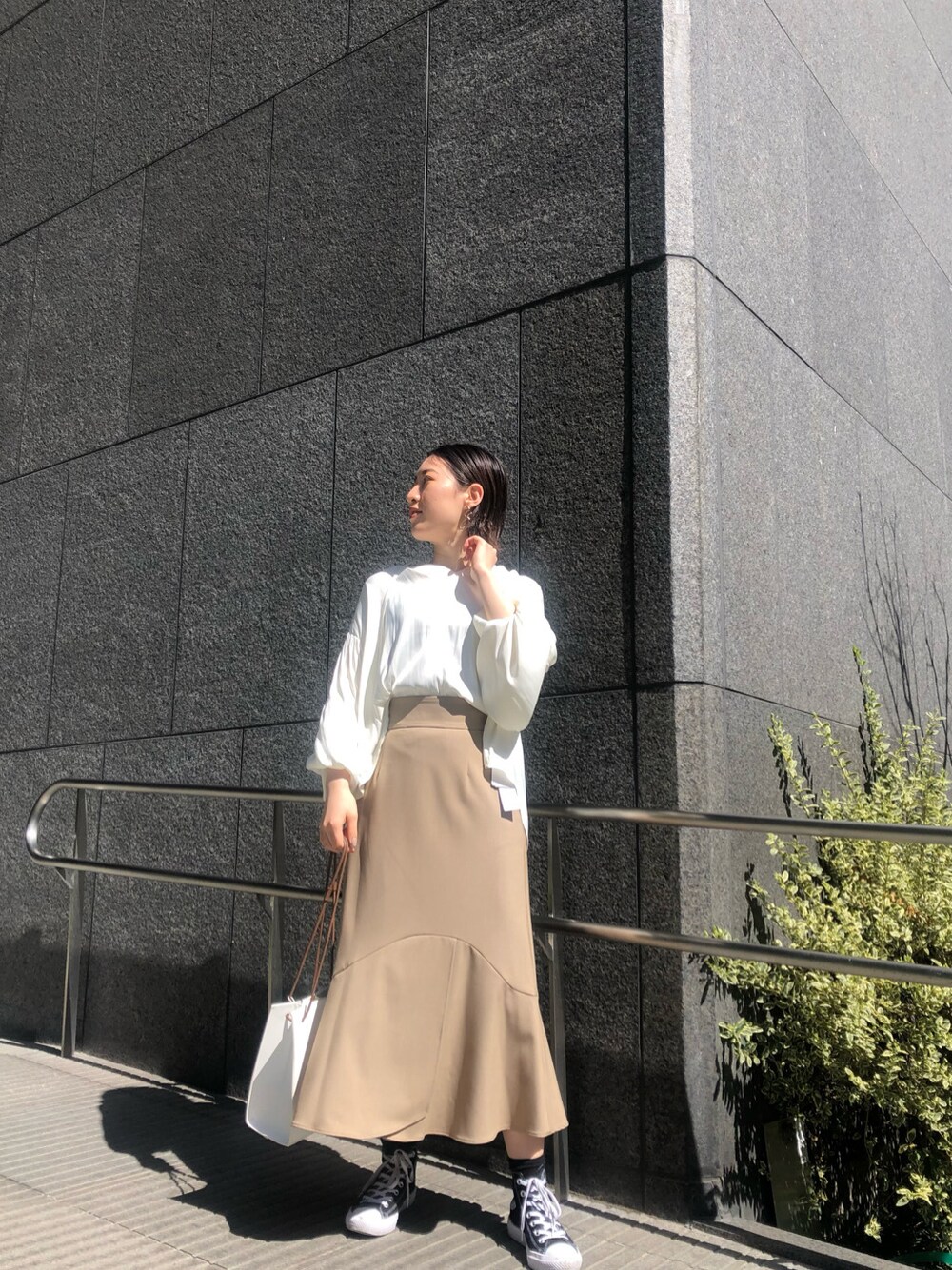 ホワイト系のシャツ/ブラウス、ベージュ系のスカート、ホワイト系のハンドバッグを着用したレディースの春コーディネートの2枚目の写真