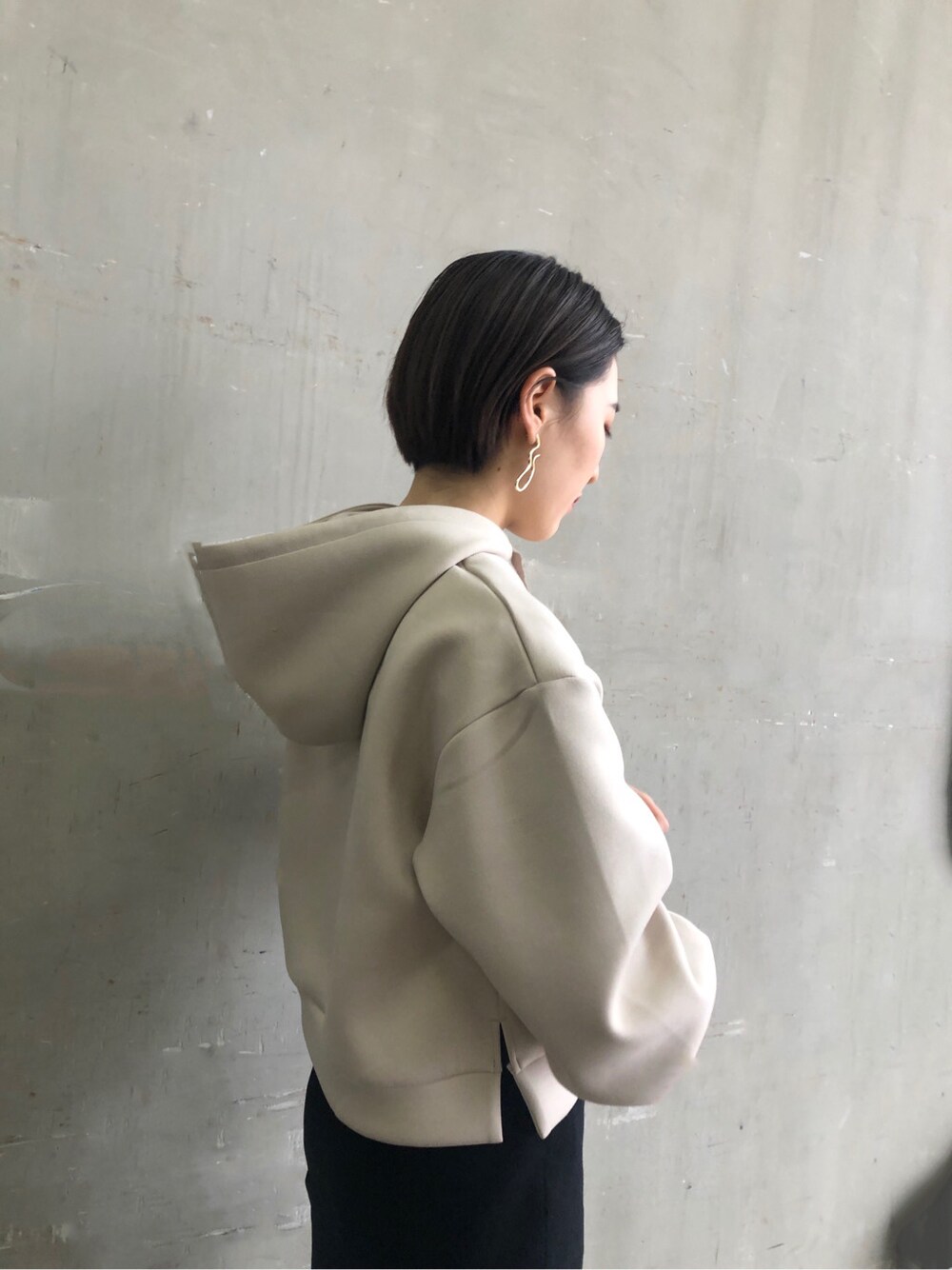 グレー系のパーカー、ブラック系のスカート、グレー系のパーカーを着用したレディースの冬コーディネートの3枚目の写真