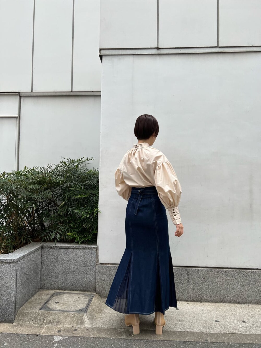 ベージュ系のシャツ/ブラウス、ベージュ系のブーツ、ブルー系のスカートを着用したレディースの春コーディネートの4枚目の写真