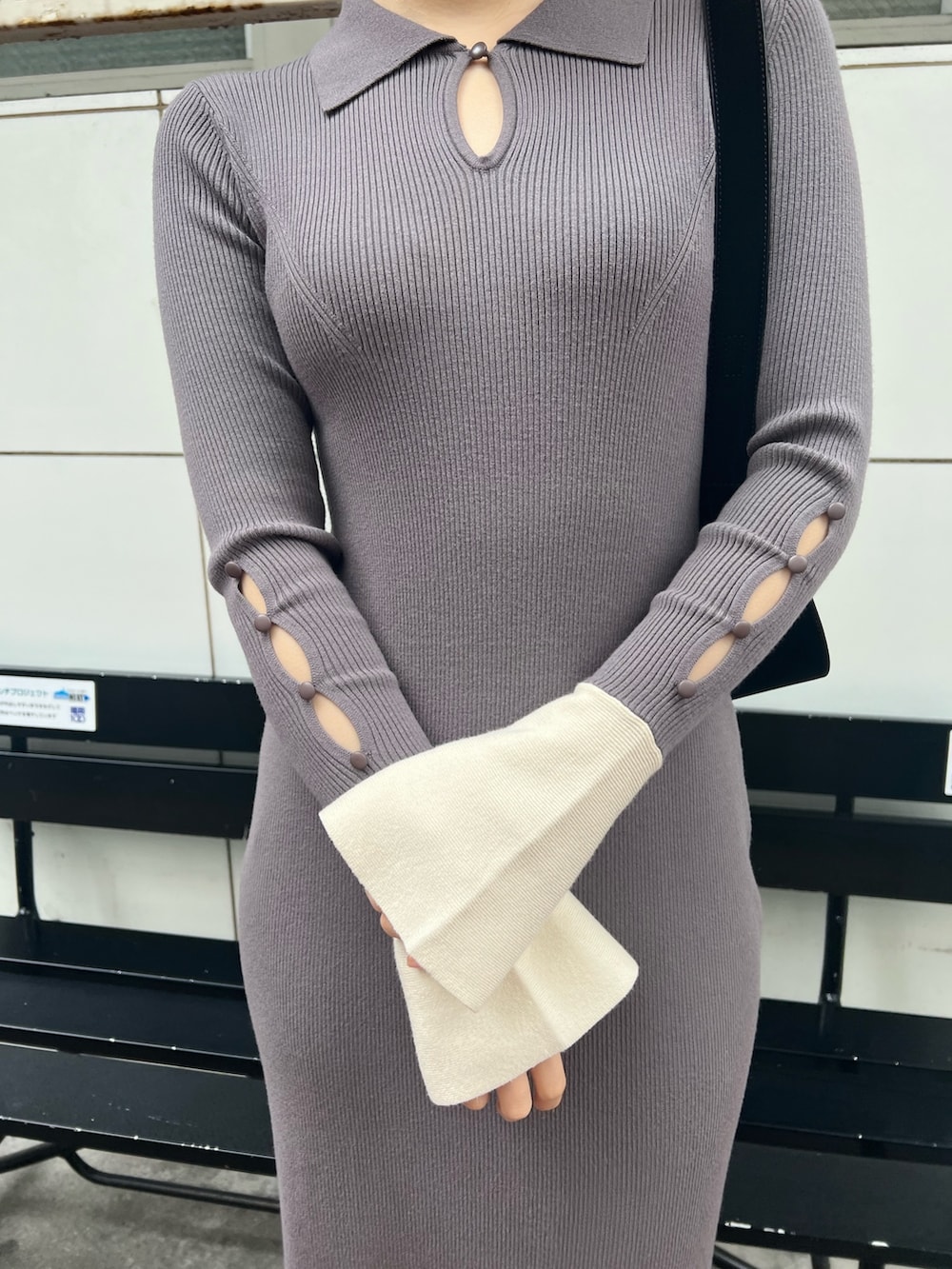 ブラック系のハンドバッグ、グレー系のワンピース、シルバー系のパンプスを着用したレディースの冬コーディネートの4枚目の写真