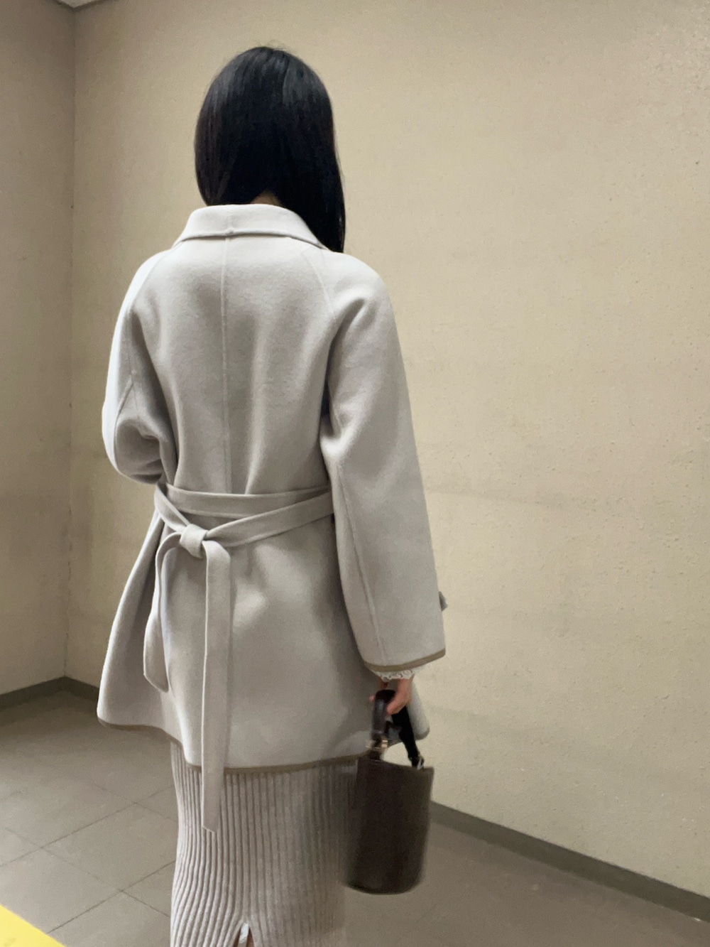 ブラック系のブーツ、ベージュ系のワンピース、ホワイト系のその他アウターを着用したレディースの秋コーディネートの5枚目の写真