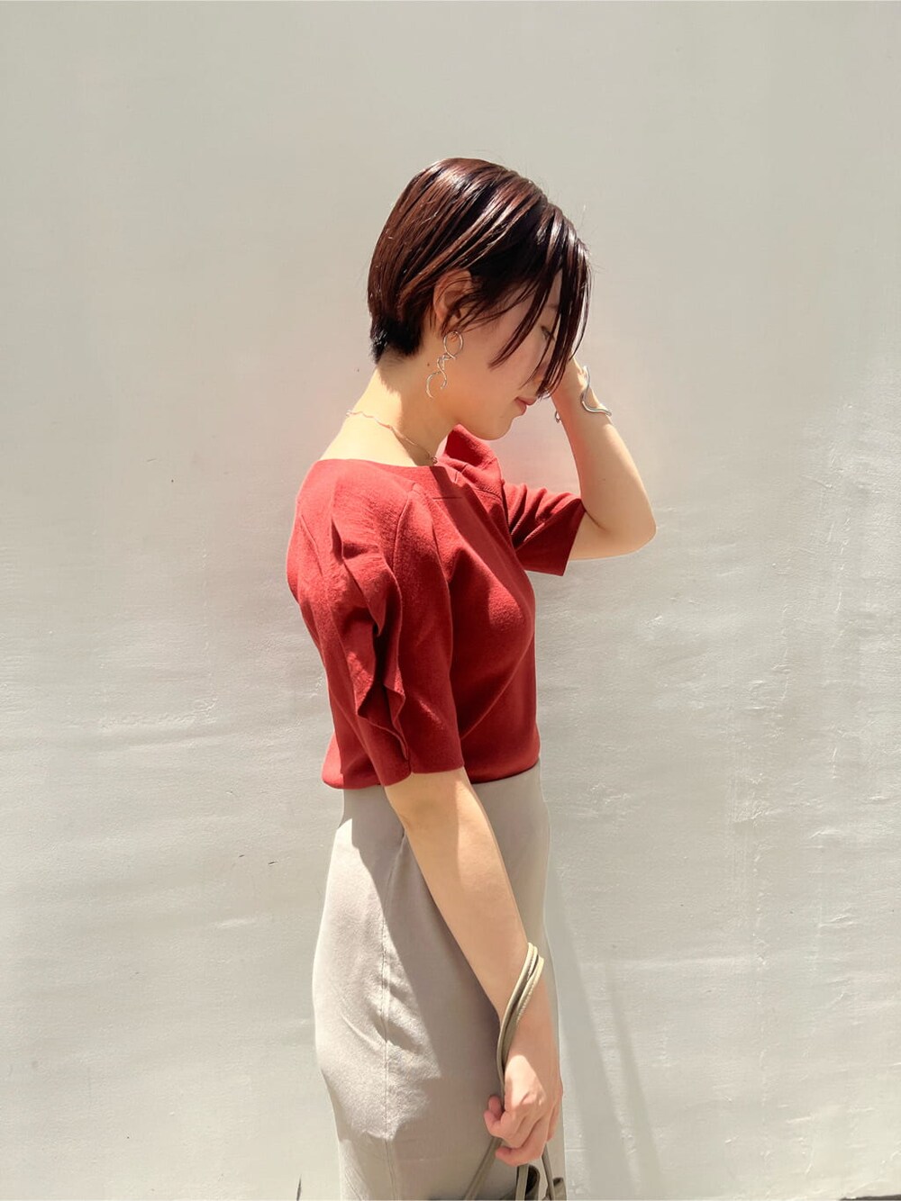 ベージュ系のハンドバッグ、ホワイト系のサンダル、ベージュ系のスカートを着用したレディースの夏コーディネートの7枚目の写真