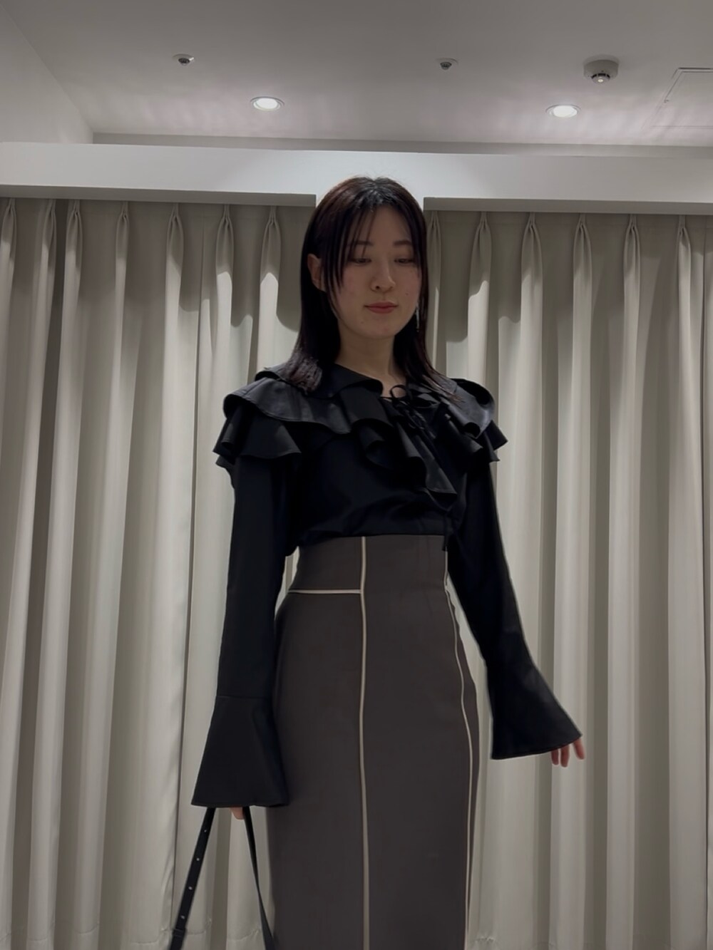 ホワイト系のシャツ/ブラウス、グレー系のスカート、ブラック系のショルダーバッグを着用したレディースの春コーディネートの4枚目の写真