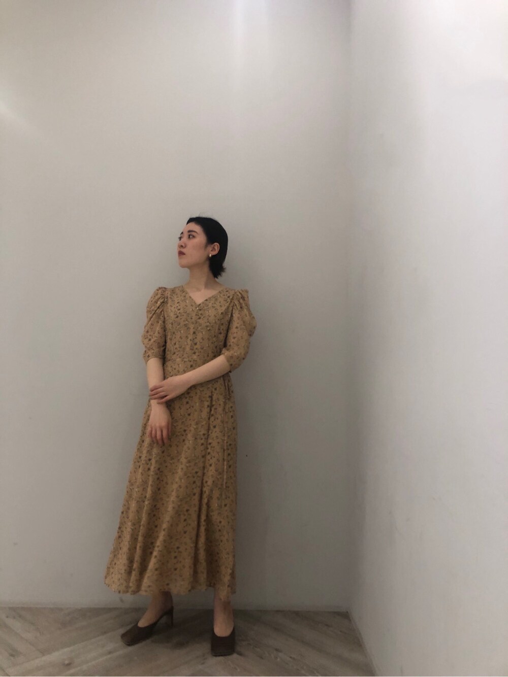 イエロー系のワンピース、ベージュ系のサンダル、グレー系のカーディガン/ボレロを着用したレディースの冬コーディネートの5枚目の写真