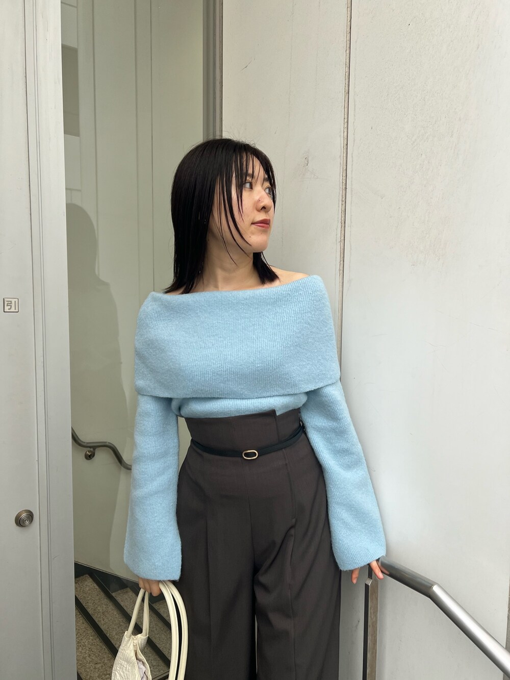 ブルー系のニット/セーター、グレー系のその他パンツ、ブラック系のブーツを着用したレディースの秋コーディネートの3枚目の写真