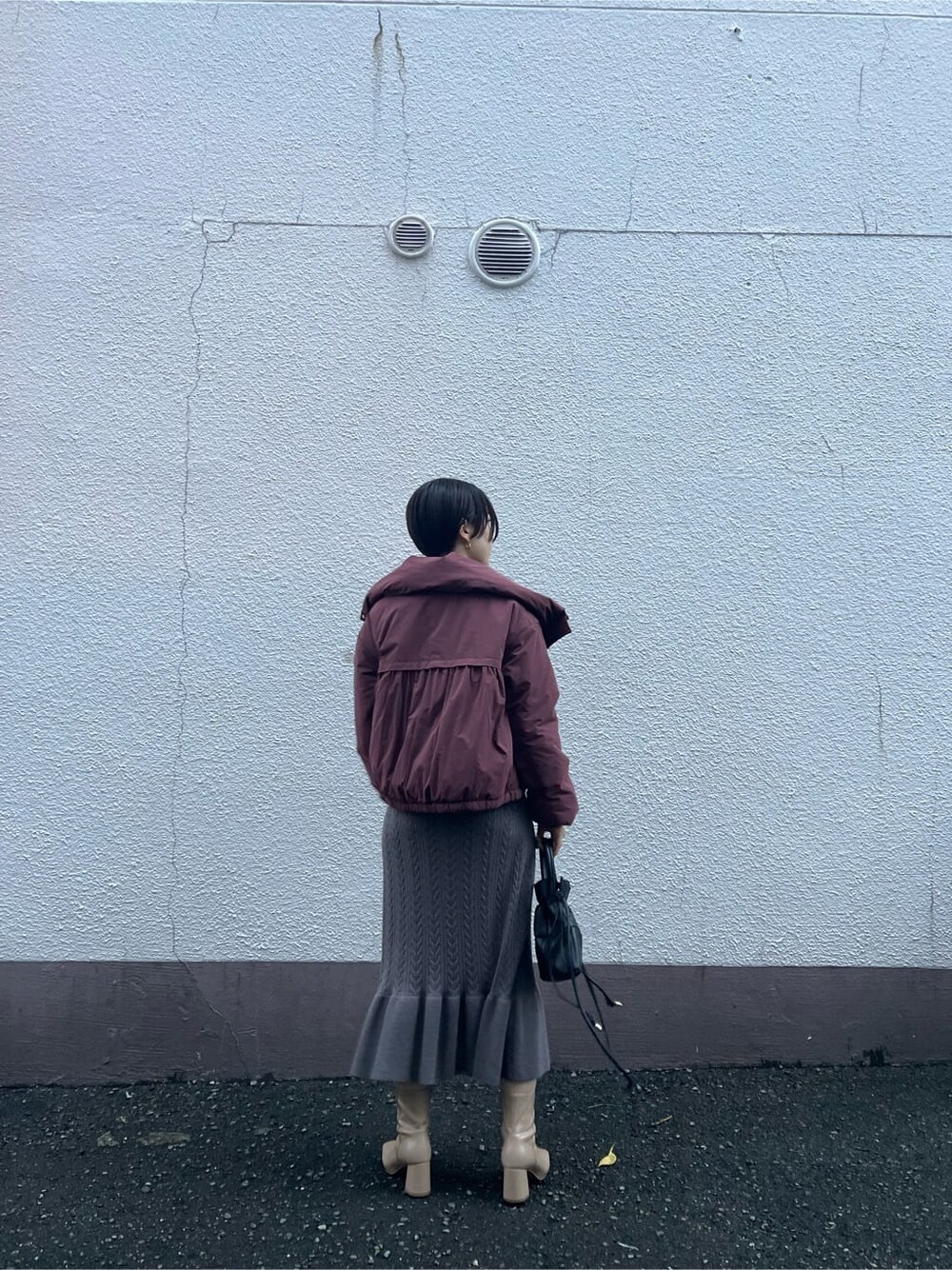 ブラウン系のワンピース、ベージュ系のブーツ、ブラック系のハンドバッグを着用したレディースの秋コーディネートの2枚目の写真