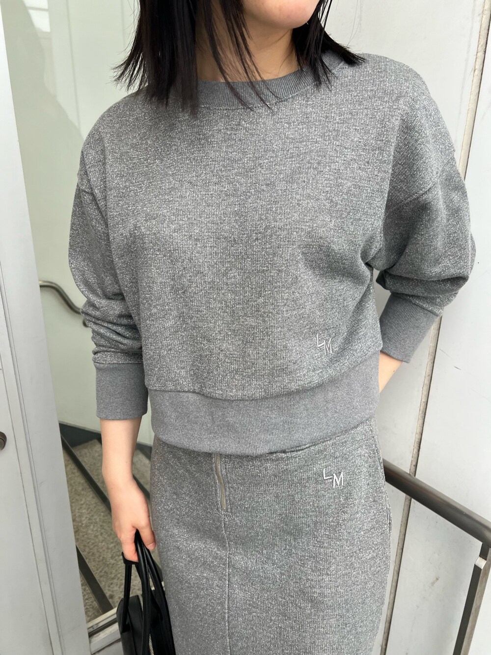 ブラック系のブーツ、グレー系のスカート、グレー系のスウェットを着用したレディースの秋コーディネートの5枚目の写真