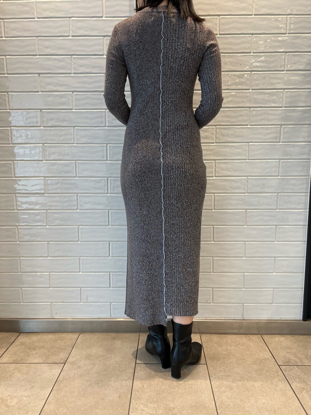 ブラック系のブーツ、ブラック系のショルダーバッグ、ブラック系のワンピースを着用したレディースの秋コーディネートの8枚目の写真