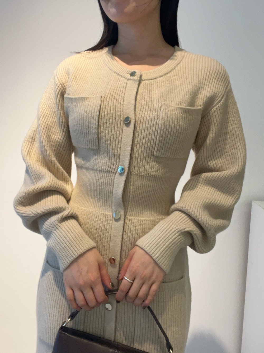 ベージュ系のワンピース、ブラウン系のハンドバッグ、ブラウン系のパンプスを着用したレディースの秋コーディネートの4枚目の写真