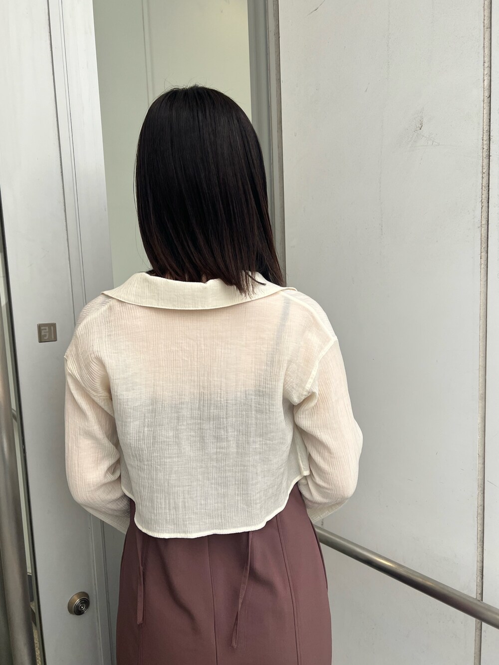 ブラック系のショルダーバッグ、ブラウン系のワンピース、ブラック系のブーツを着用したレディースの秋コーディネートの10枚目の写真