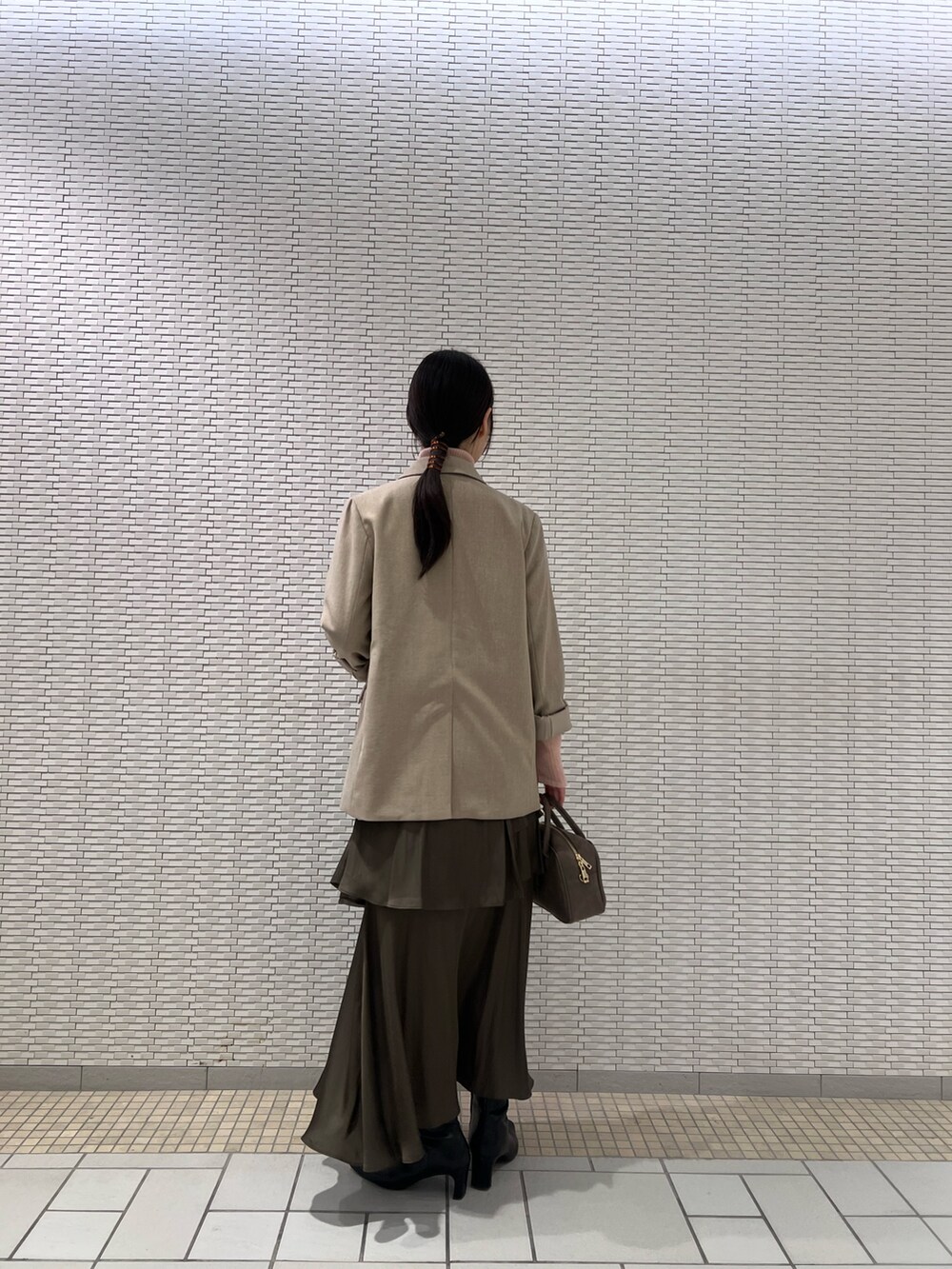 ピンク系のニット/セーター、ブラック系のブーツ、ベージュ系のテーラードジャケットを着用したレディースの秋コーディネートの3枚目の写真