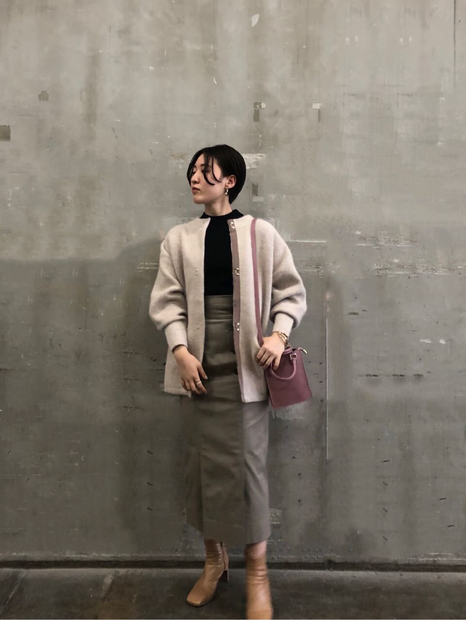 ピンク系のショルダーバッグ、ベージュ系のカーディガン/ボレロ、グレー系のスカートを着用したレディースの秋コーディネートの2枚目の写真